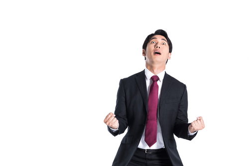 何かが漏れたことに気づき上を見上げるスーツ姿の会社員