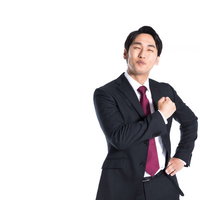 笑顔で心臓を捧げる会社員の誠意と信頼感を表現した胸に手を当てるポーズの写真