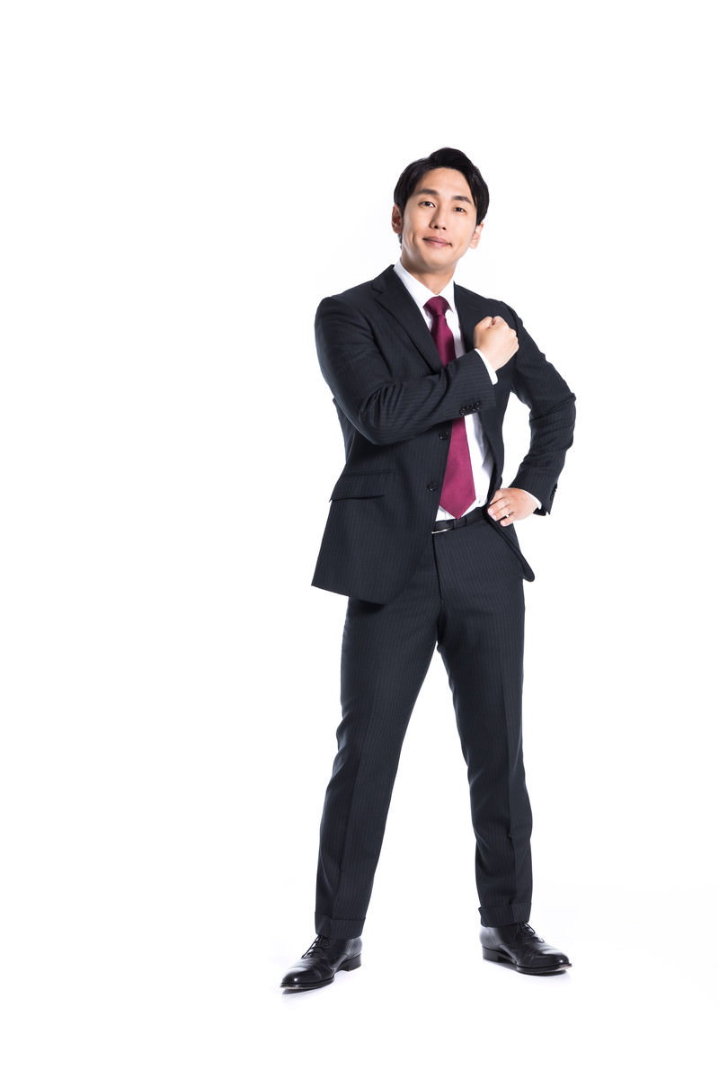 黒いスーツを着てガッツポーズをとる男性会社員［モデル：大川竜弥］