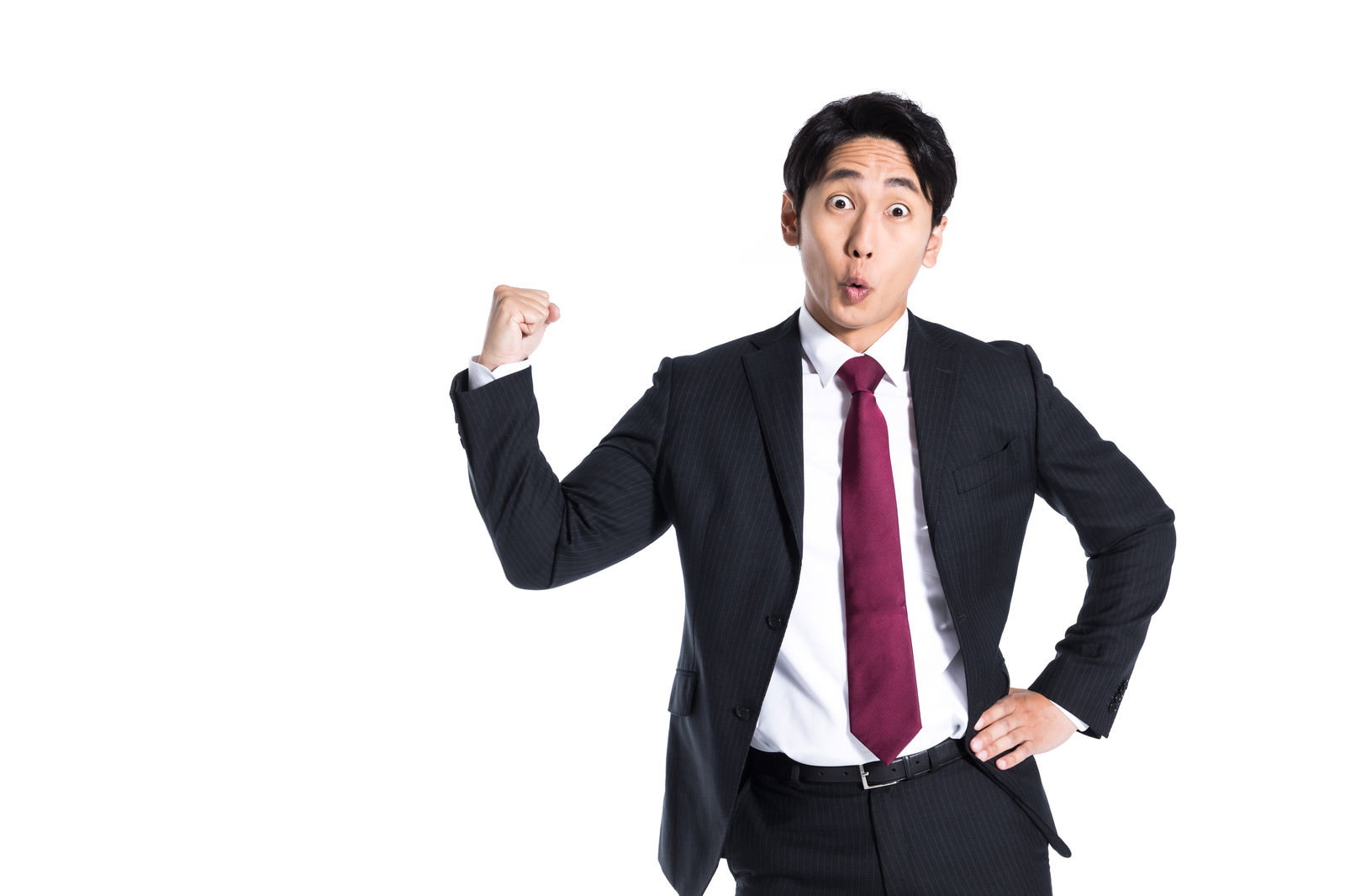 黒いスーツと赤いネクタイを着てガッツポーズをする男性［モデル：大川竜弥］