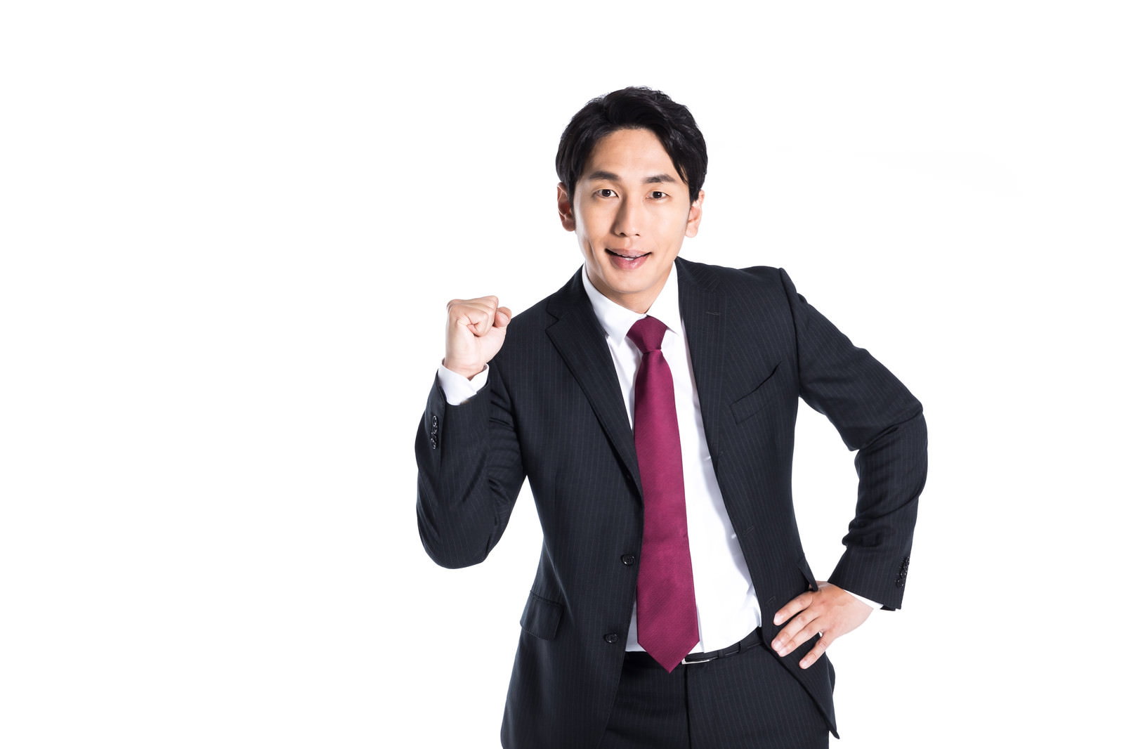 紺色のスーツに赤いネクタイの会社員がガッツポーズを決めている［モデル：大川竜弥］