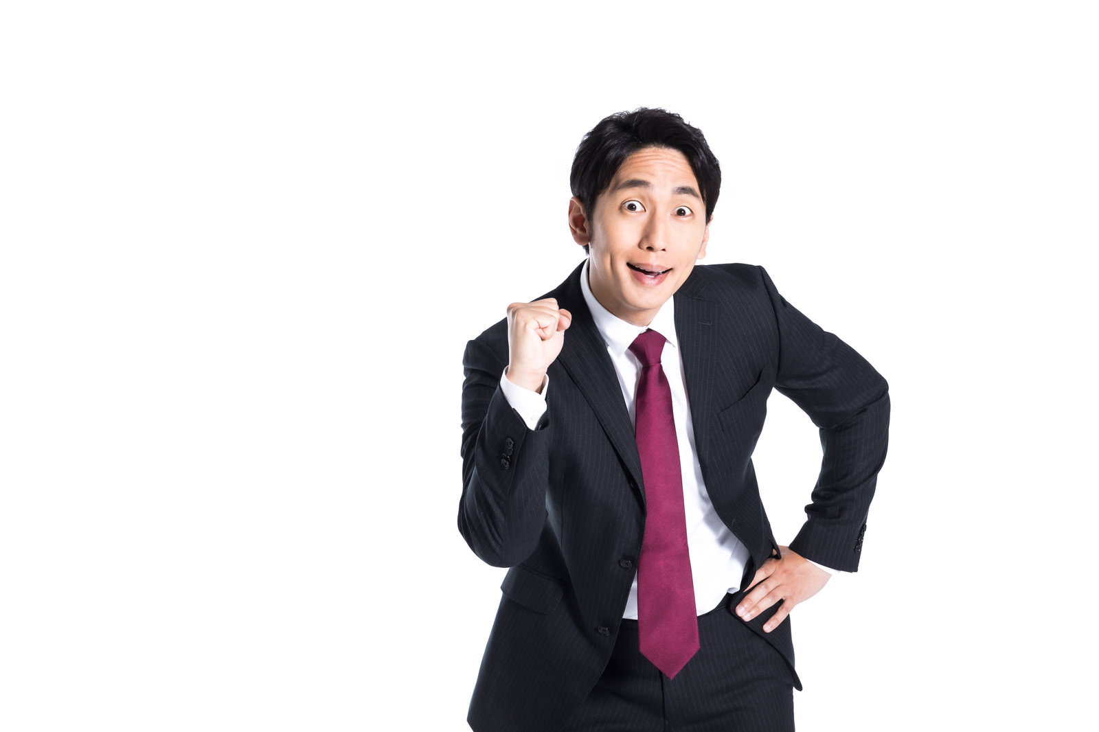 黒いスーツに赤いネクタイの会社員がガッツポーズをしている［モデル：大川竜弥］