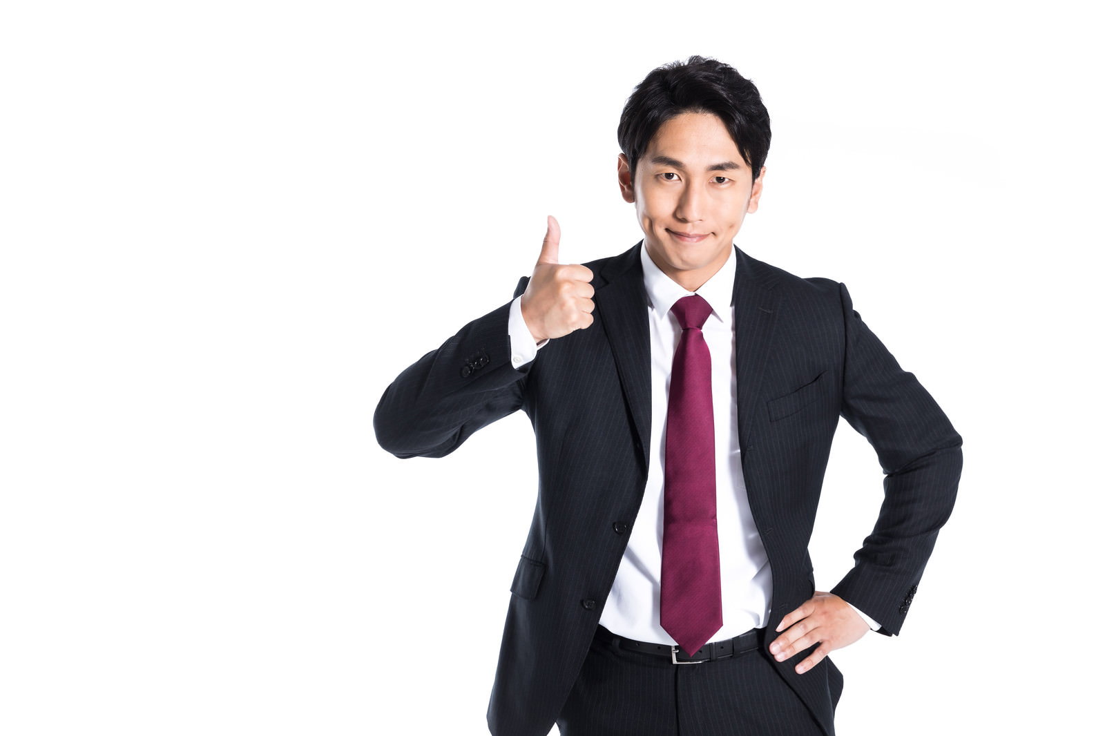 黒いスーツに赤いネクタイを着用した男性が親指を立てるポーズ［モデル：大川竜弥］