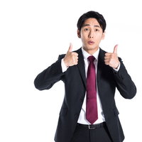 両手でいいねのポーズをするスーツ姿のサラリーマンの写真