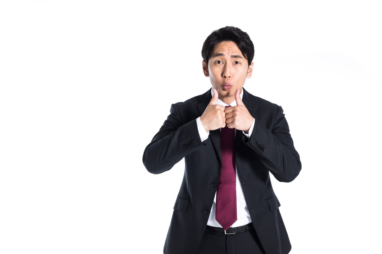 両手で親指を立てていいねのポーズをするスーツ姿の会社員男性［モデル：大川竜弥］