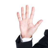 5本の指を広げて制止のポーズを取るビジネスマンの手の写真