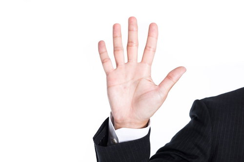 5本の指を広げて制止のポーズを取るビジネスマンの手