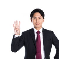 スーツ姿で4番を指さす男性のポーズの写真