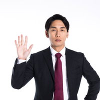 停止を指示する右手を掲げるビジネスマンの写真