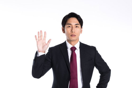 停止を指示する右手を掲げるビジネスマン