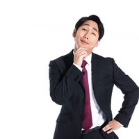 顎に手を当てて偉そうな態度を取るしゃくれ男性の写真