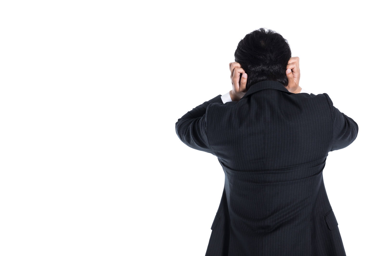 頭を抱えて困惑している黒いスーツの会社員男性の後ろ姿［モデル：大川竜弥］