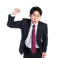 拳を振り上げ殴りかかろうとする怒りの会社員の写真