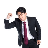 拳を振り上げ威嚇する激おこ上司の怒りの表情の写真