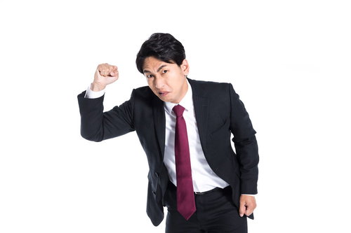 拳を振り上げ威嚇する激おこ上司の怒りの表情