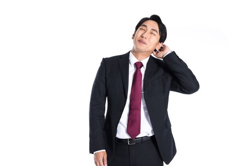 上司にほめられてまんざらでもない照れる会社員