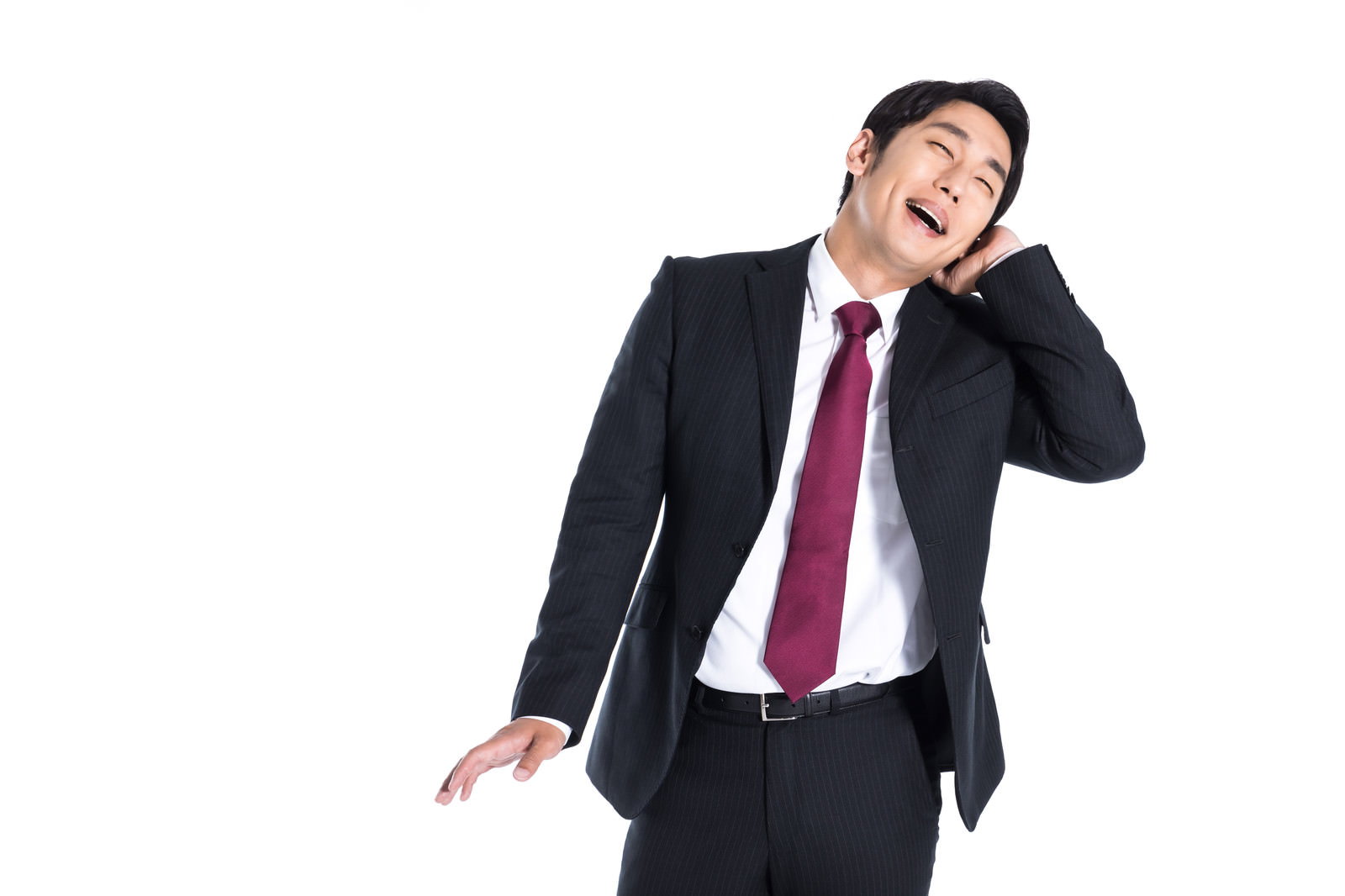 紺色のスーツを着た会社員男性が片手を頭に当てて照れながら微笑んでいる［モデル：大川竜弥］