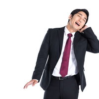 褒められて照れくさそうに喜ぶ会社員男性のポートレートの写真