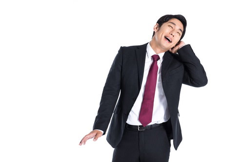 褒められて照れくさそうに喜ぶ会社員男性のポートレート