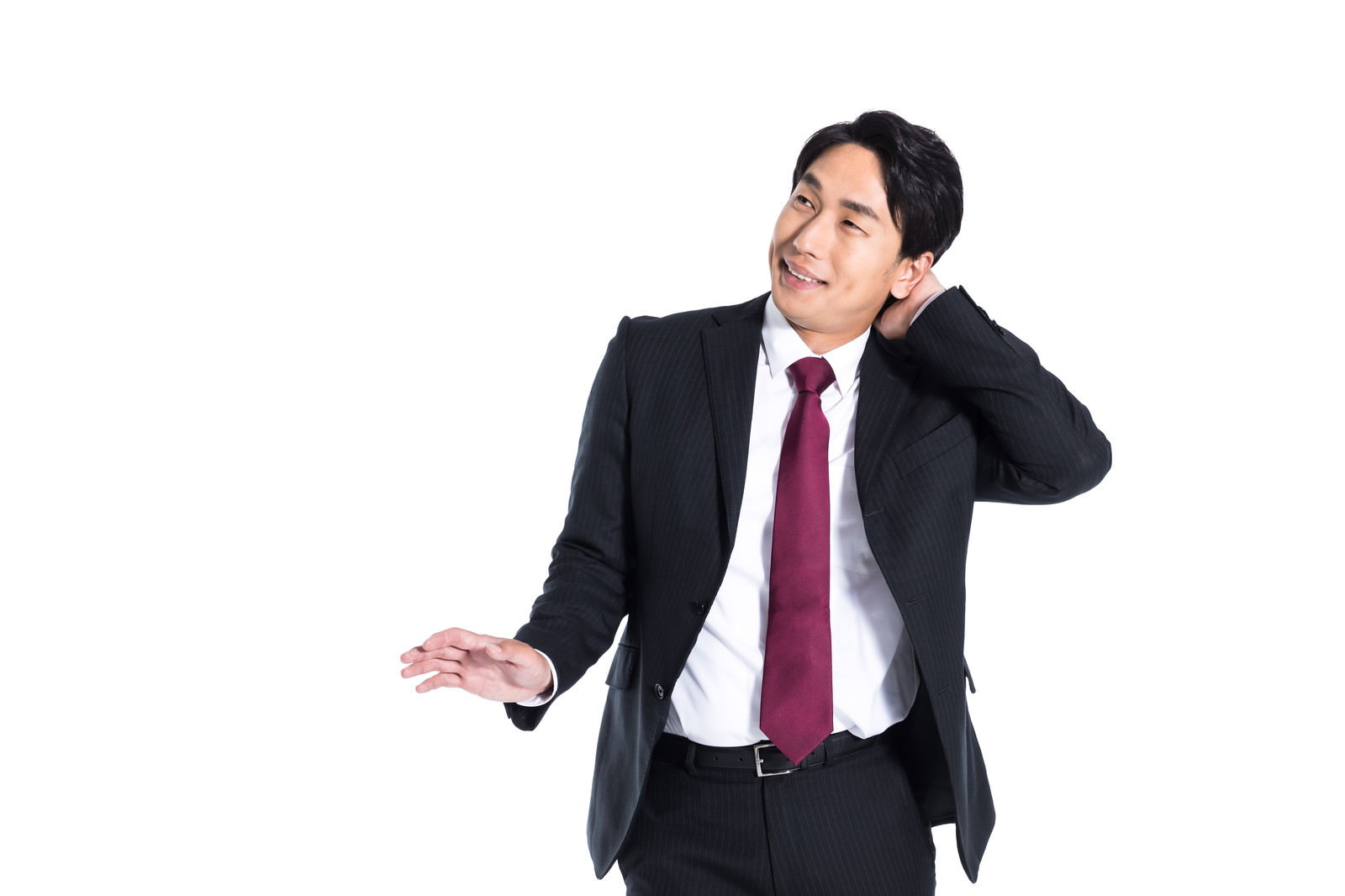 黒いスーツに赤いネクタイの男性会社員が照れて頭をかいている様子［モデル：大川竜弥］