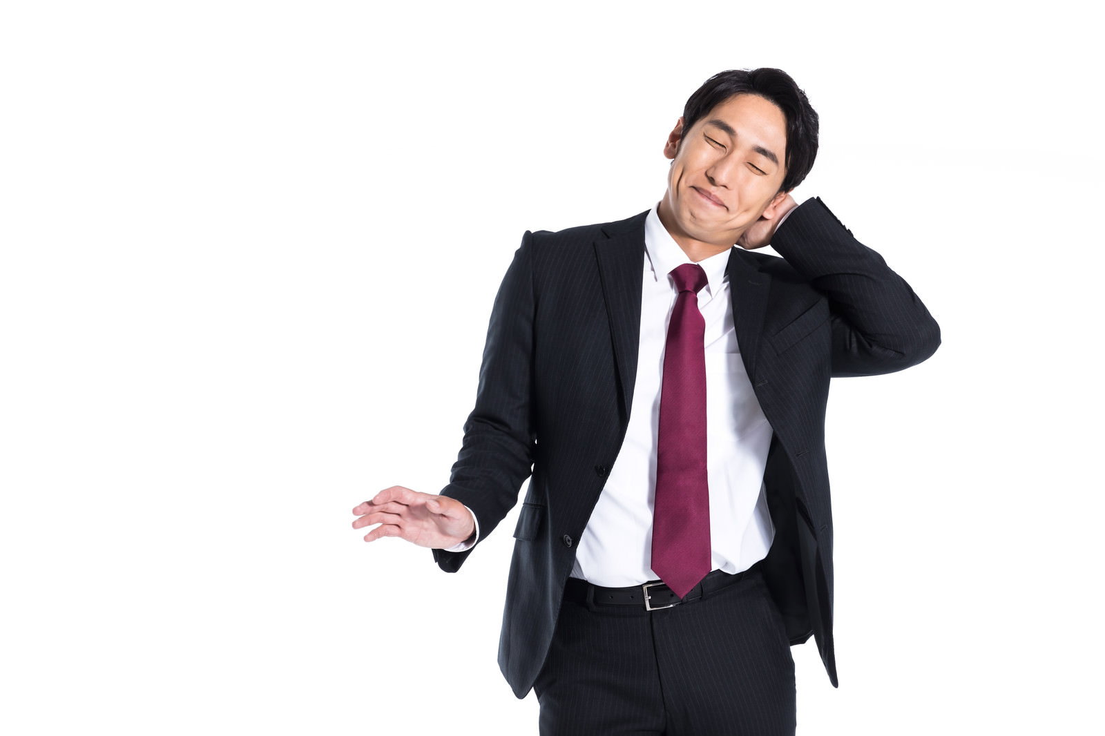 黒いスーツを着て頭に手を当てながら恥ずかしそうに照れる新入社員の男性［モデル：大川竜弥］