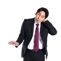 まんざらでもない様子で照れ笑いする会社員の写真