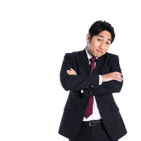 肩の力を抜こうよ、と腕組みして呆れる会社員男性の写真