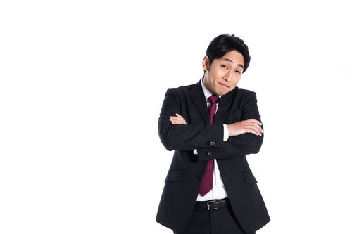 肩の力を抜こうよ、と腕組みして呆れる会社員男性