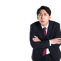 冷房が効きすぎて寒そうにする会社員男性のオフィスの写真