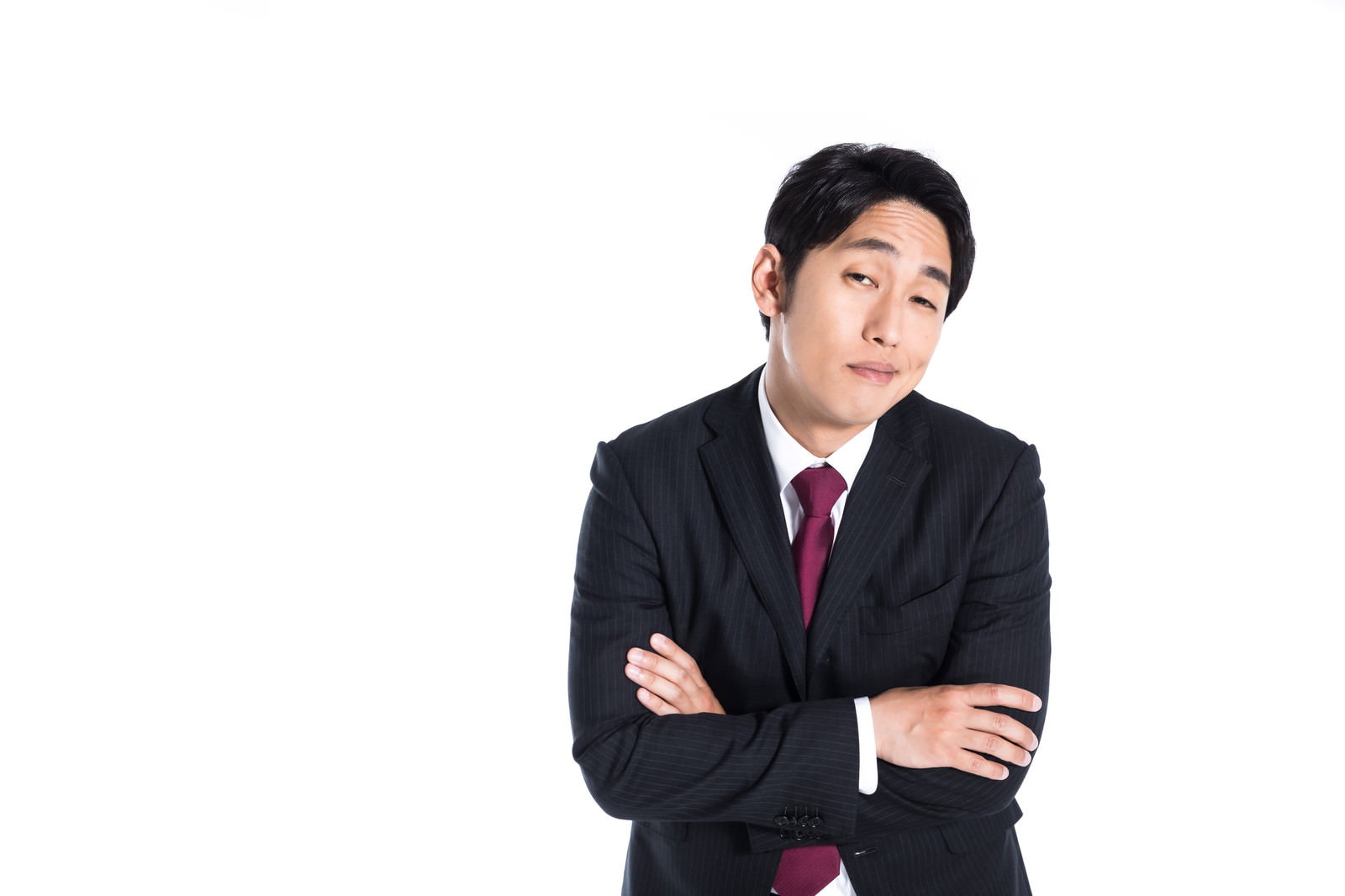 黒いスーツを着た男性が腕組みをして偉そうな表情をしている［モデル：大川竜弥］
