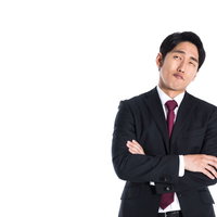 決断に悩む会社員の困った表情と腕を組む姿勢の写真