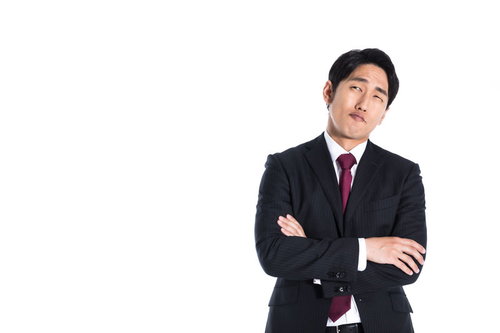 決断に悩む会社員の困った表情と腕を組む姿勢