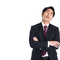 苦悩と葛藤で腕を組み考え込むビジネスマンの写真