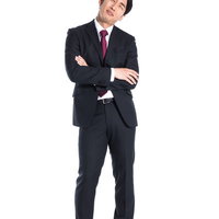 課題に直面し腕組みで考え込むスーツ姿の男性の写真