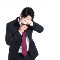 顔を覆いながら号泣する男性会社員の写真