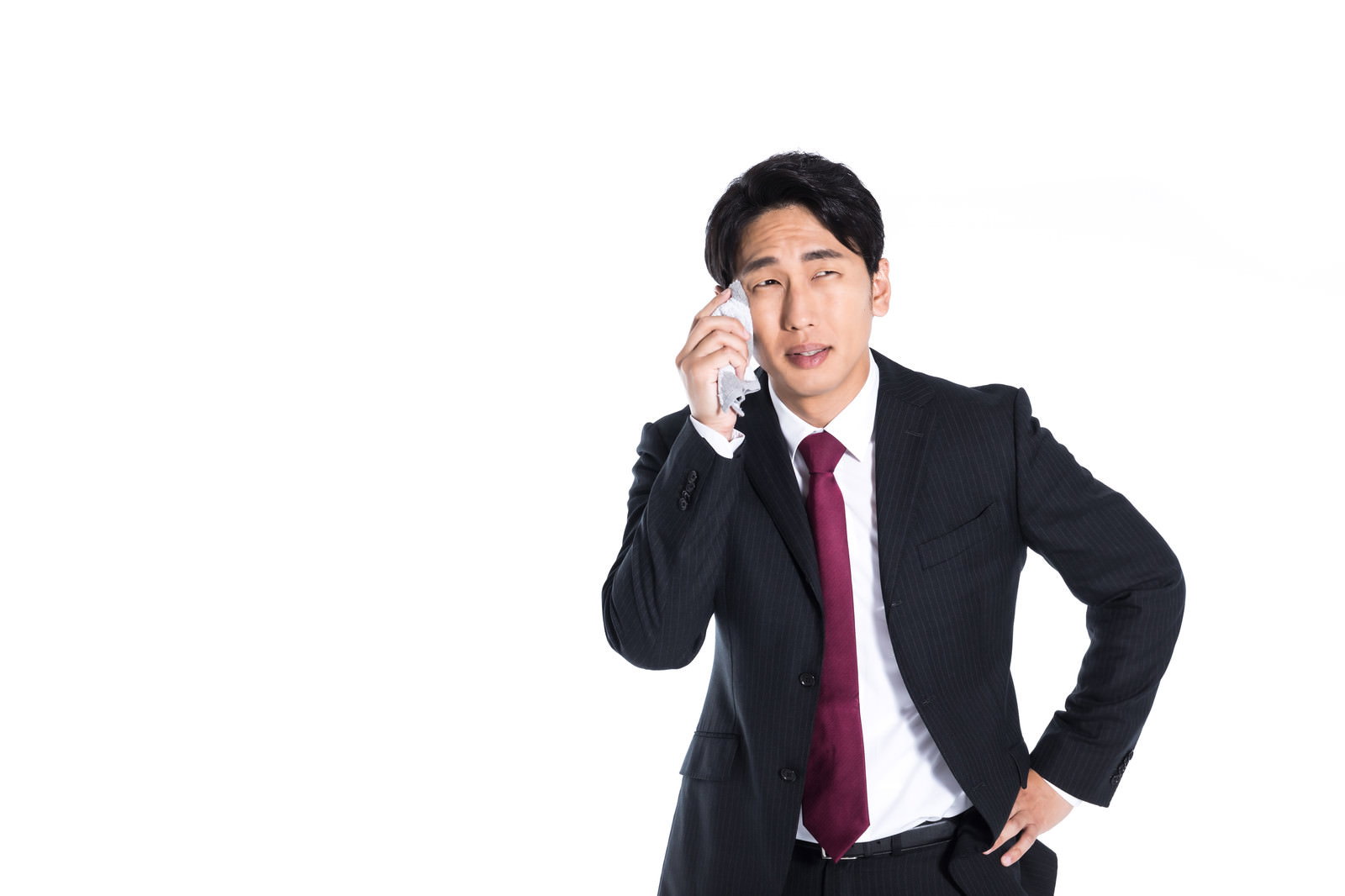 ハンカチを持つスーツ姿の会社員男性が夏の暑さに対応している［モデル：大川竜弥］