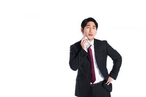 黒いスーツのサラリーマンがハンカチで汗を拭きながら営業