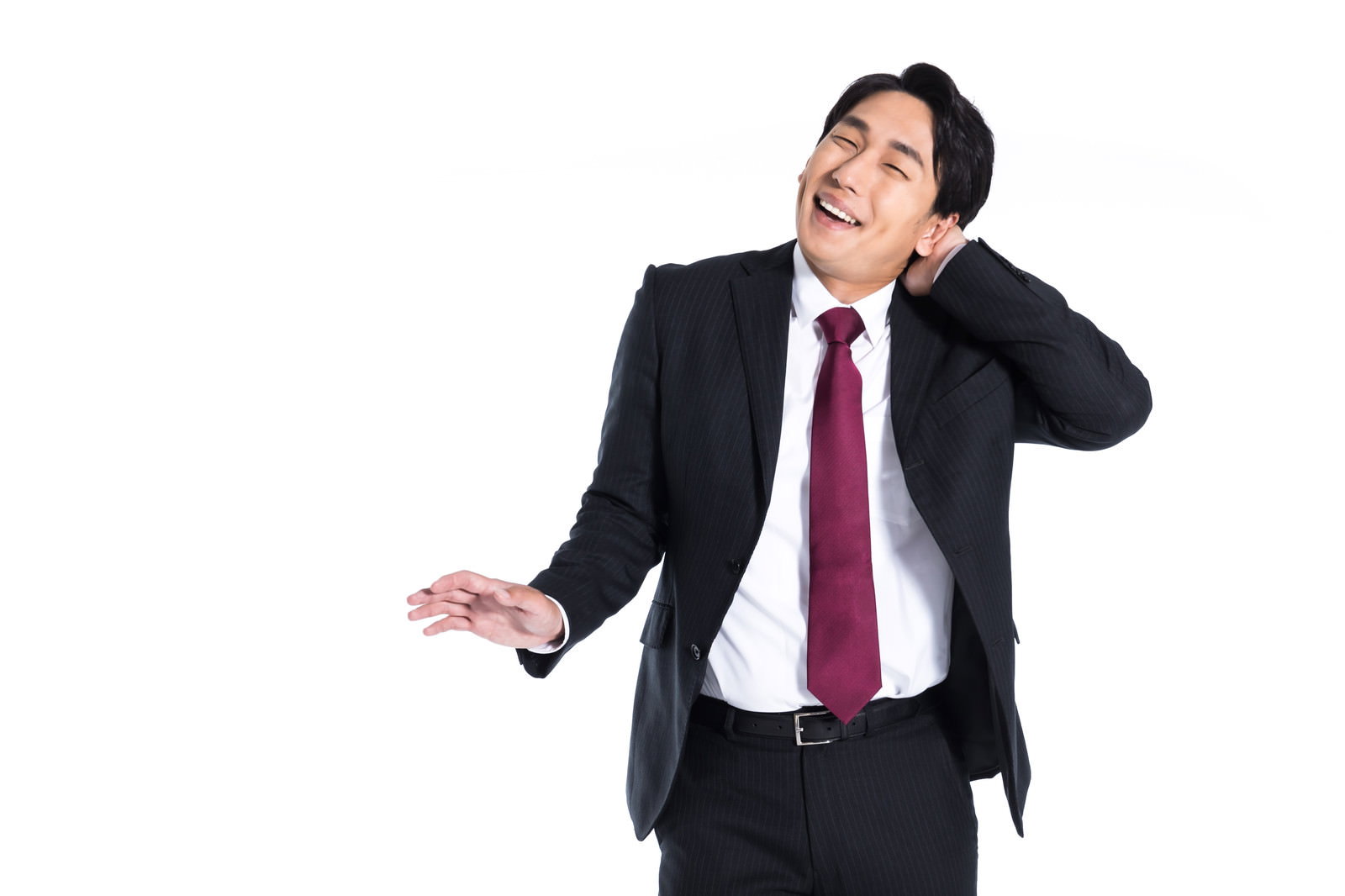 紺色のスーツを着た男性が苦笑いを浮かべながら頭を掻いている様子［モデル：大川竜弥］