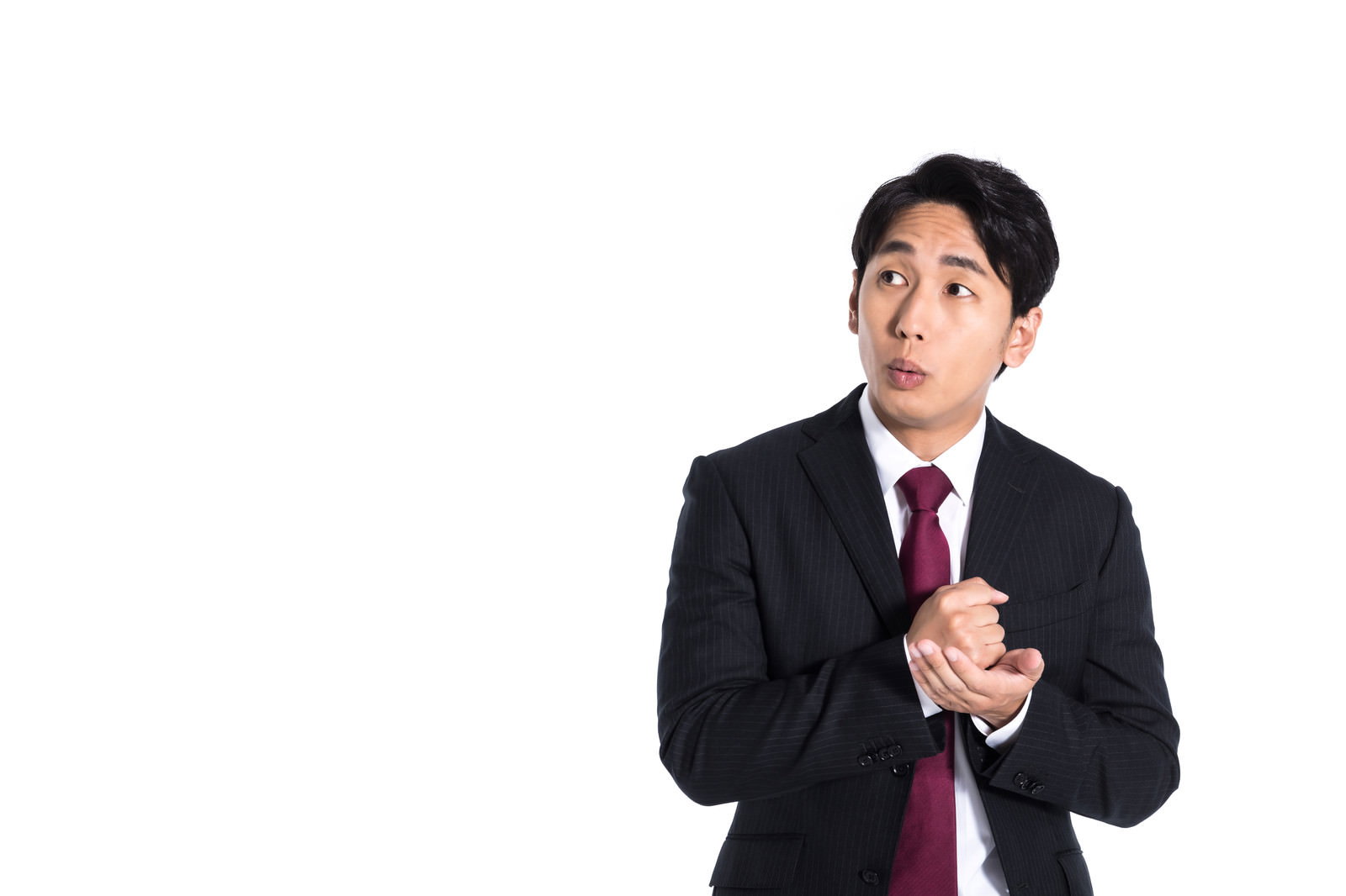 両手を合わせて納得の表情を見せる黒いスーツの会社員男性［モデル：大川竜弥］