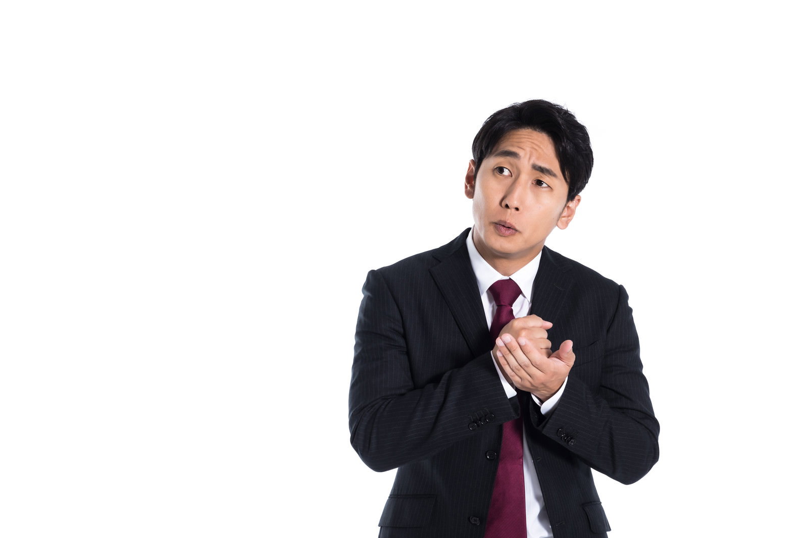 スーツ姿の男性が両手を構えて困惑した表情で上を見ている［モデル：大川竜弥］