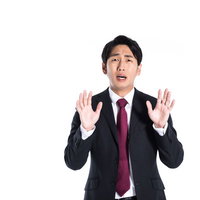想定外の指摘に両手を上げて困惑する男性の写真