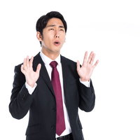 お手上げで唖然とするスーツ姿のビジネスマンの写真