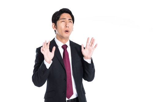 お手上げで唖然とするスーツ姿のビジネスマン