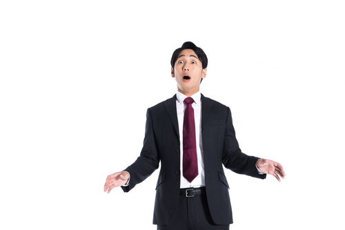 予想外の朗報に両腕を広げて驚く会社員