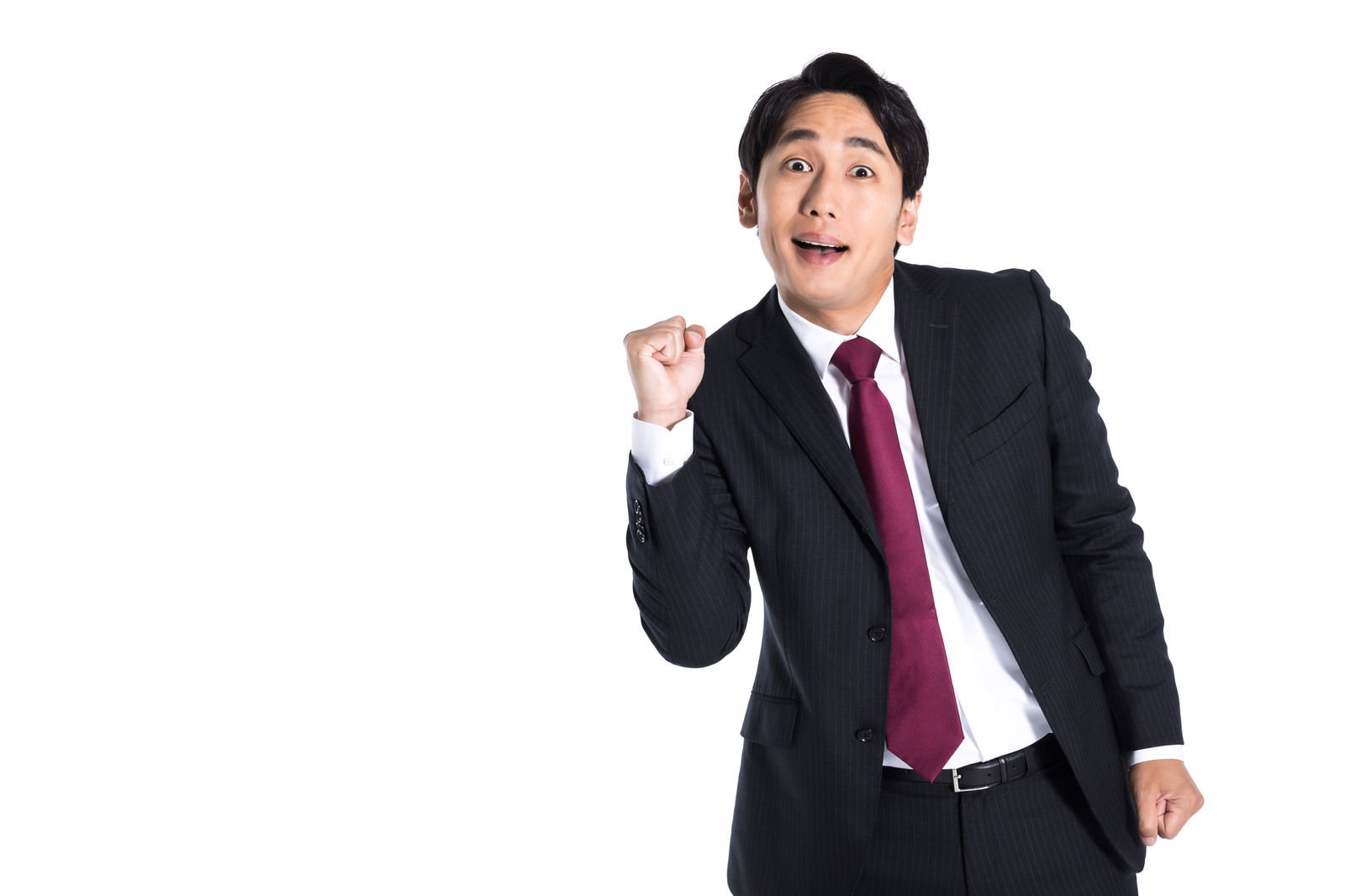 疲れ切った表情で拳を握りガッツポーズを取る営業マンの男性［モデル：大川竜弥］