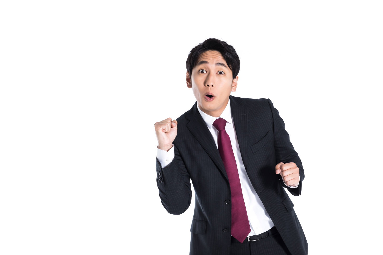 拳を握ってガッツポーズをする紺色スーツの会社員男性［モデル：大川竜弥］