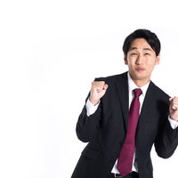完全に腰の引けたファイティングポーズを取るスーツ姿の会社員男性の写真