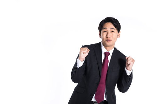 完全に腰の引けたファイティングポーズを取るスーツ姿の会社員男性