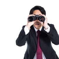 不正をロックオンするエージェント・双眼鏡で監視する男性の写真