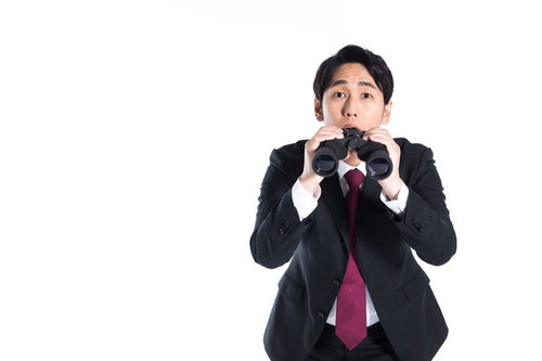 双眼鏡からひょっこり顔を出す黒いスーツの会社員男性